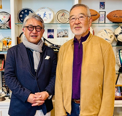 廣川信也とジャックK・坂崎氏(右)。数多くのスポーツメモラビリア(記念品)の前で
